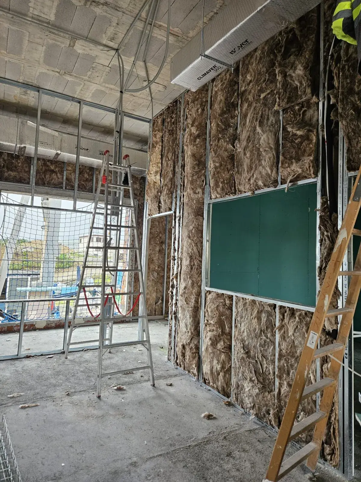 Trasdosado con lana mineral y placa hidrófuga verde en una obra de Ceuta
